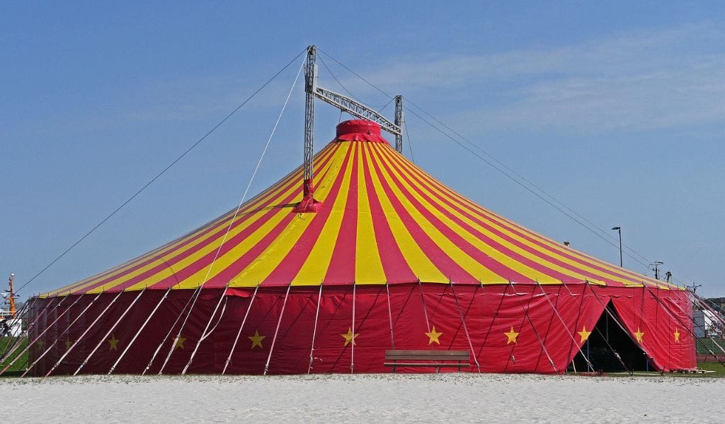 Bright red and yellow circus tent with stars, ideal for outdoor festivals, gatherings, and entertainment events.