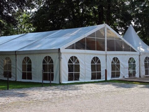 Spacious tent with clear side walls and windows set up for an outdoor corporate event or gathering in Dhaka